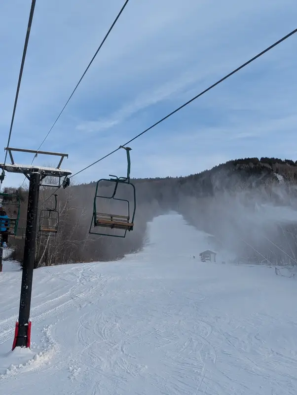 Chairlift and snowmaking on a winter morning